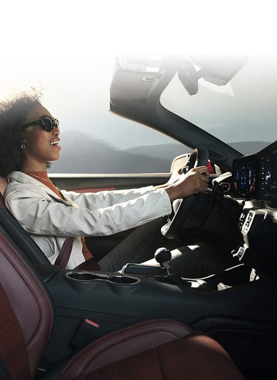 Person sitting in the driver’s seat of a 2024 Ford Mustang® convertible | Freeport Ford in Freeport IL